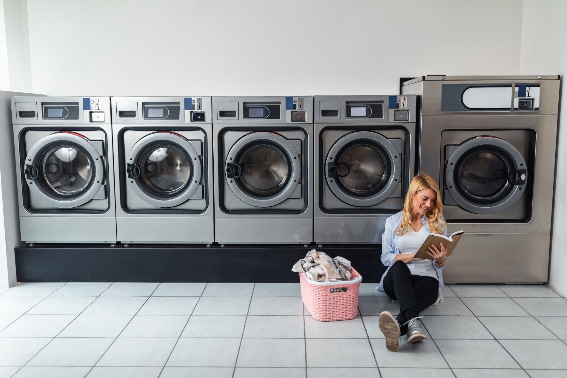 woman reading inside laundromat min